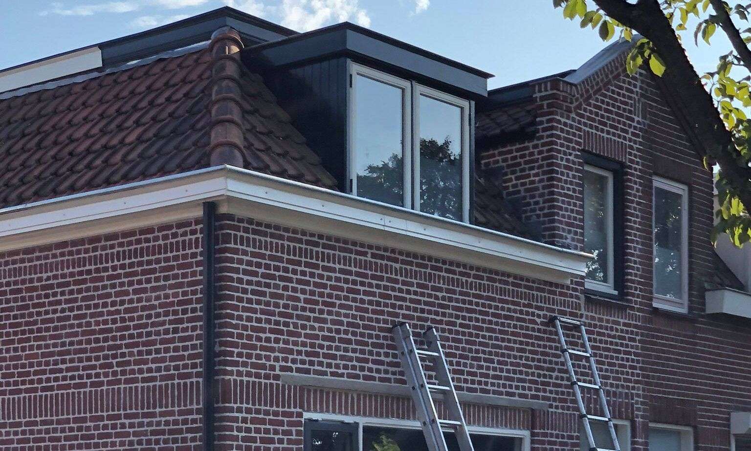 Met de ladden een dakgoot inspecteren in Monnickendam